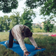 The girl is at a yoga session in the park, on a blue mat. - PhotoDune Item for Sale