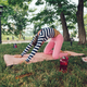 In the park, a sporty girl is participating in yoga and stretching her body. - PhotoDune Item for Sale