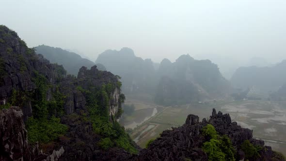 The limestone karst eroded mountains of Tam Coc on Ninh Binh province Vietnam during foggy day, Aeri alt