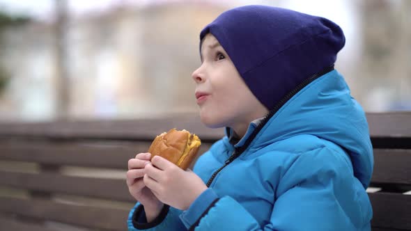 Hungry Kid Eating Double Cheeseburger Outdoor