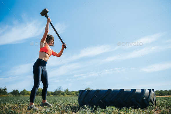 Crossfit Powerhouse Woman Demonstrates Strength, Hitting Rubber Tire with Hammer
