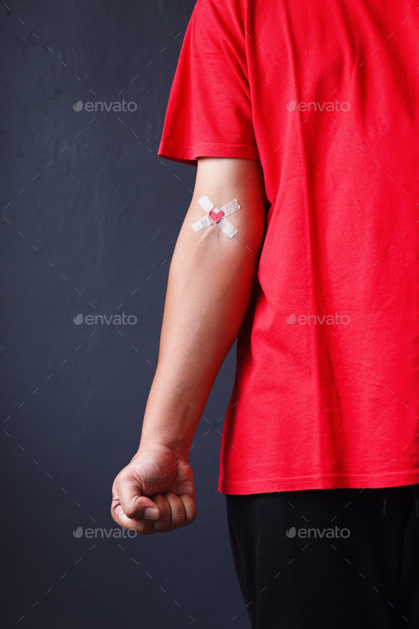 Clenched fist of a man hand showing plaster after donation blood Stock