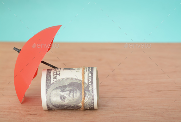 Red umbrella and money banknotes with copy space. Money protection and safety assurance concept