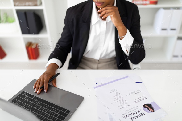 HR employee looking at cv resume of candidates, analyzing information before job interview, sitting