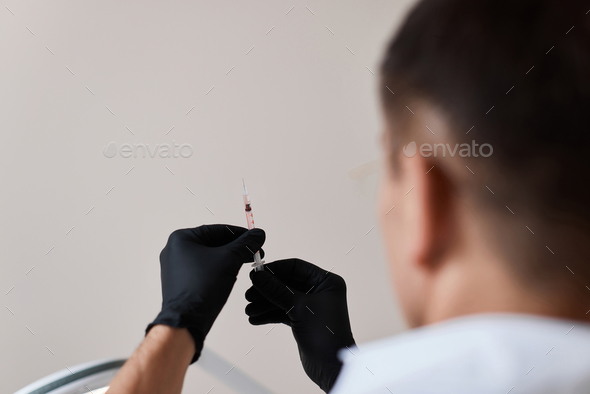 Physician hand with the syringe for injection