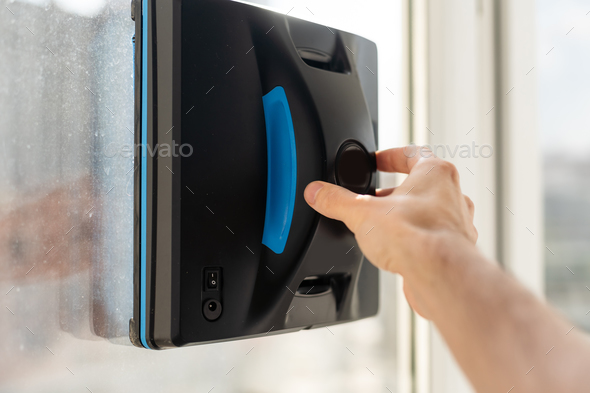 The white robotic window cleaner uses a brush and vacuum for a thorough cleaning. The automatic