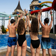 Rear view of a group of young people having fun at the water park. - PhotoDune Item for Sale