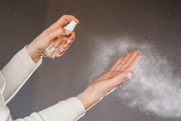 Hands applying alcohol spray or anti bacteria spray. Personal hygiene concept. Coronavirus. Cleaning
