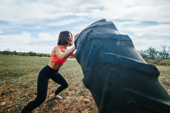 Strength and Determination CrossFit Woman Lifting a Wheel Outdoors