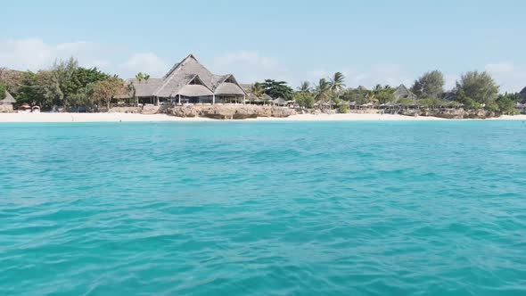View From Boat to the Coast of Zanzibar with Paradise Beach Palms and Hotels alt