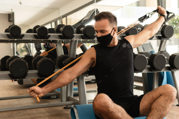 Man exercising with a rubber resistance band in the gym