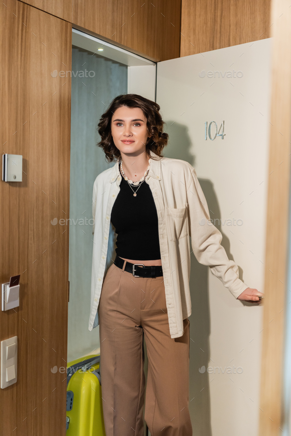 delighted woman in stylish clothes, white shirt and beige pants