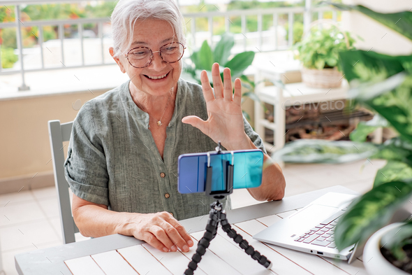 Senior influencer woman creating social media videos with smartphone camera