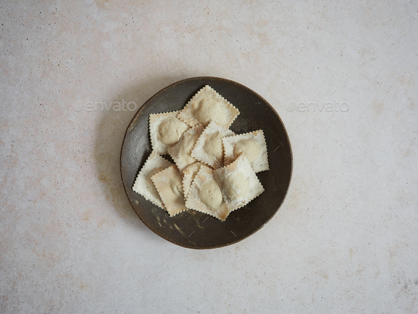 fresh filled pasta, uncooked ravioli in a dark plate isolated, top view  Stock Photo by anal74