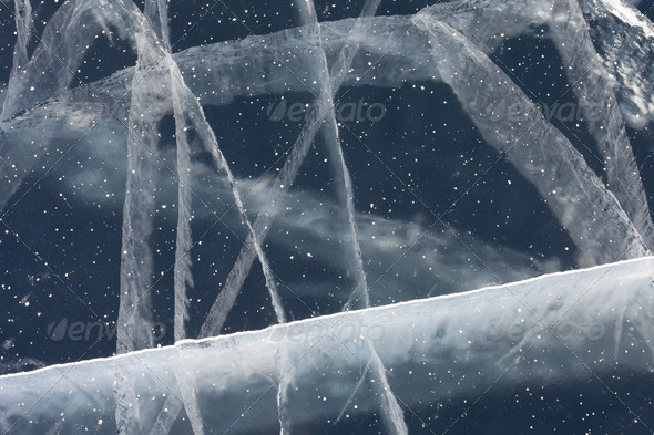 Spider web of tension cracks in thick layer of ice - Stock Photo - Images