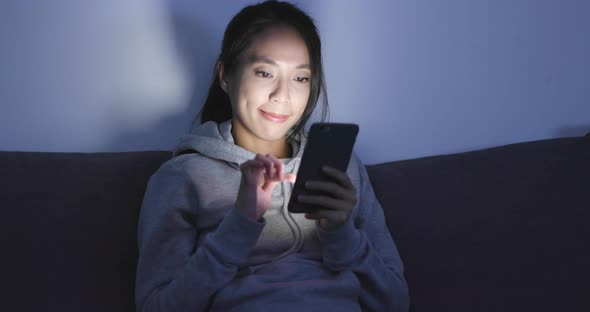 Woman look at smart phone at home alt