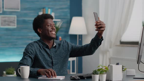 Authentic Happy African American Man Taking a Selfie in the Living Room to Share It on Social Media alt