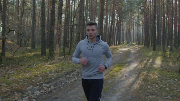 Strong Caucasian Man Is Running In Forest