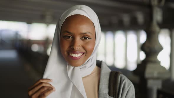 Happy Black Woman Hides Face Behind Hijab Under Bridge alt