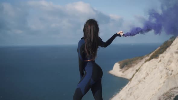 Slow Motion Back View Sexy Young Athletic Woman Stands on Cliff alt