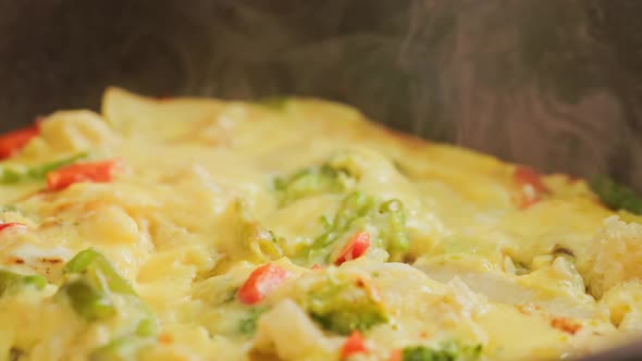 Steam Rises From the Skillet with an Omelet with Fresh Vegetables  Extreme Closeup