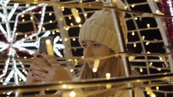 Woman Photographing Christmas Decorations with a Phone