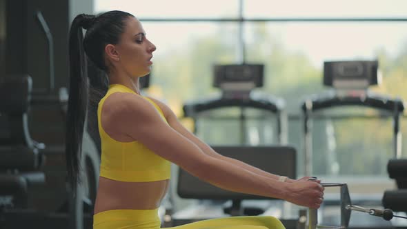 Hispanic Woman Does Exercises on the Rowing Machine alt