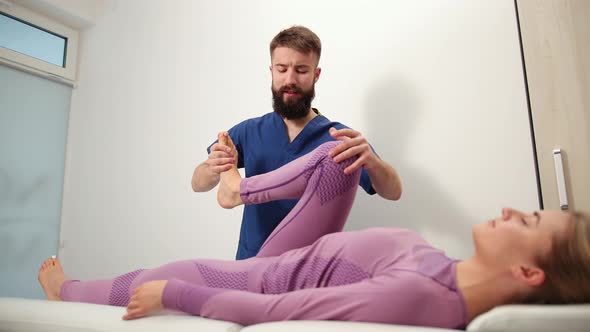 Therapist Doing Healing Treatment on Female Leg Knee alt