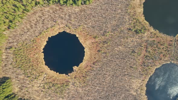 AERIAL: Strange Looking Lakes That Resembles Alien Face with Reflections on Water Surface
