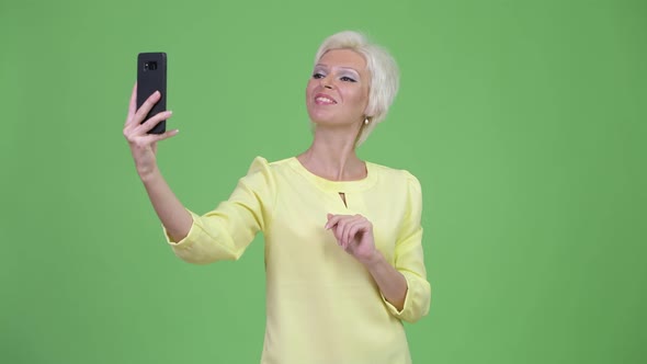 Happy Beautiful Businesswoman with Short Blond Hair Taking Selfie
