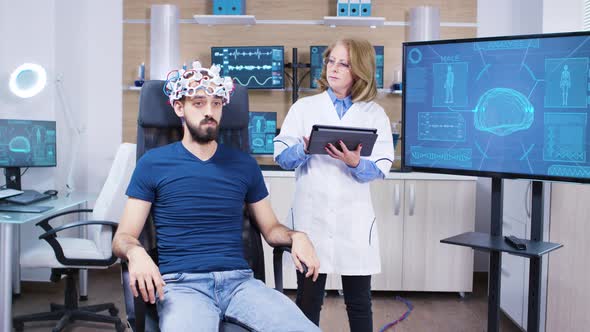 Female Doctor Checking the Brain Activity of Male Patient alt