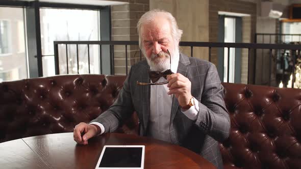 Handsome Mature Businessman in Classic Suit and Eyeglasses Working in His Office. alt