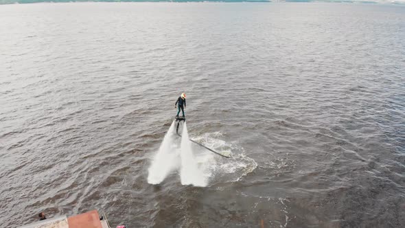 Water Sports  a Man Training Flying Over the Water on the Flyboard Near an Island  Aerial View alt