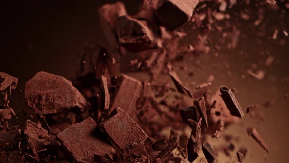 Super Slow Motion Shot of Raw Chocolate Pieces and Cocoa Powder After Being Exploded at 1000Fps. alt
