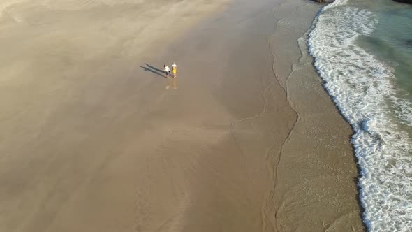 Aerial Shot of Two Woman Walking Along Beach