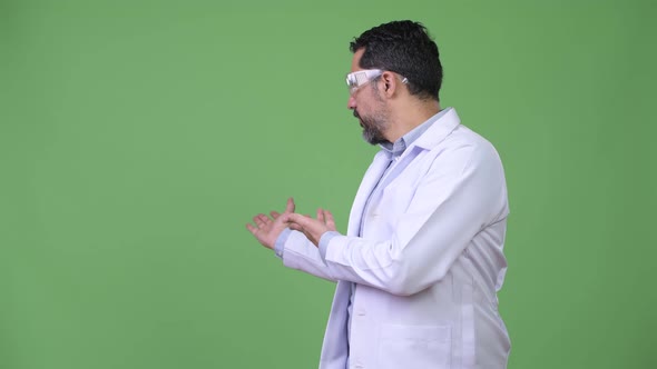 Handsome Persian Bearded Man Doctor Wearing Protective Glasses and Showing Something