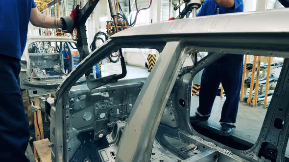 Metal Body of a Car Is Getting Welded By the Technicians alt