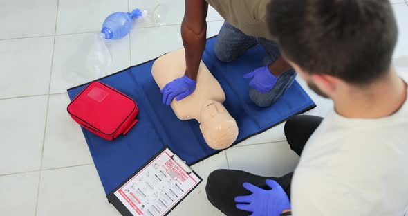 Closeup of Students Practicing CPR Chest Compression on Teen Dummy alt