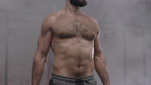 Sportsman Lifting Dumbbells in Gym alt