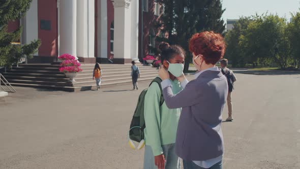 Woman Seeing Girl Off to School Amidst Pandemic alt