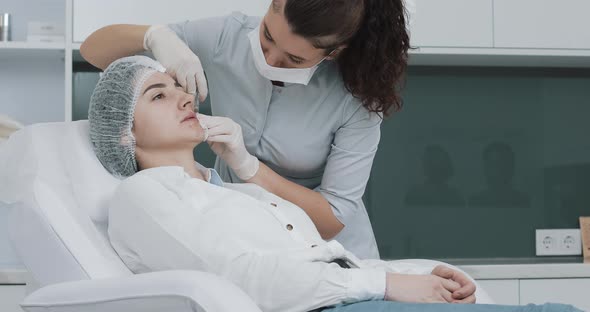 Lip Augmentation. The Doctor Cosmetologist Makes Lip Augmentation Procedure of a Beautiful Woman in alt