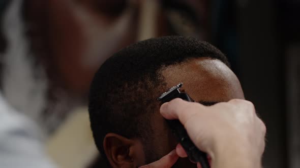 The Trimmer Cuts the Curled Hair of an African American  Macro Shot alt