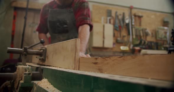 The Master Cuts a Wooden Board with a Circular Saw in the Woodworking Workshop of a Small Furniture alt