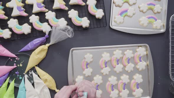 Step by step. Flat lay. Decorating unicorn theme sugar cookies with royal icing on baking sheet alt