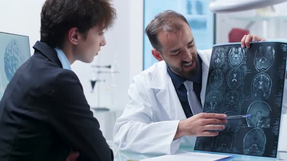 Doctor Showing To a Patient a Detailed X Ray Scan alt