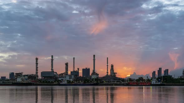 Oil refinery petrochemical and energy industry sun rise, night to day, zoom out - Time-lapse