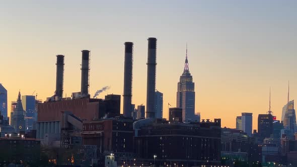 silhouetted New York City skyline cityscape at sunset golden hour view from Hudson River alt