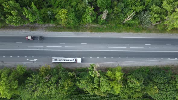 Truck Tractor and Cars View From Above on the Asphalt Road High Above the Trees alt