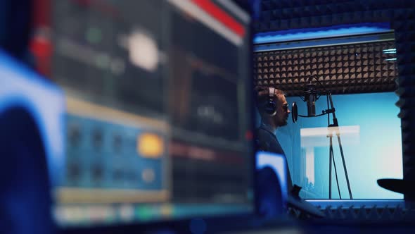 Male Rap Singer with Headphones and Sound Engineer Are Recording a New Song alt