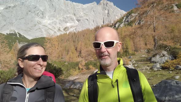 4K Sporty Couple Hiking in Alpine Landscape on Sunny Autumn Day